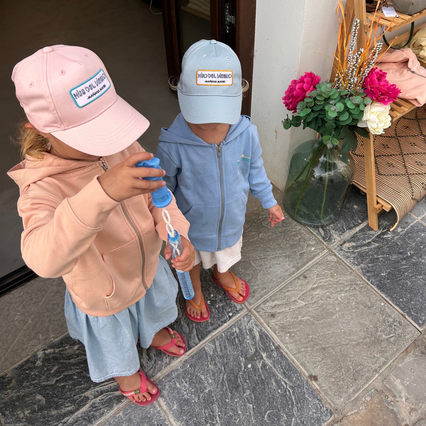 Kids wearing Sustainable caps in front of the shop
